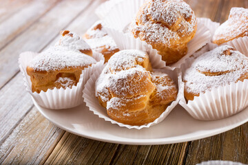 A view of a plate of cream puff pastries.