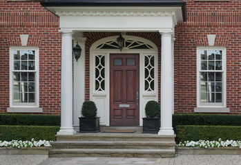 Elegant home entrance with wood grain door and portico
