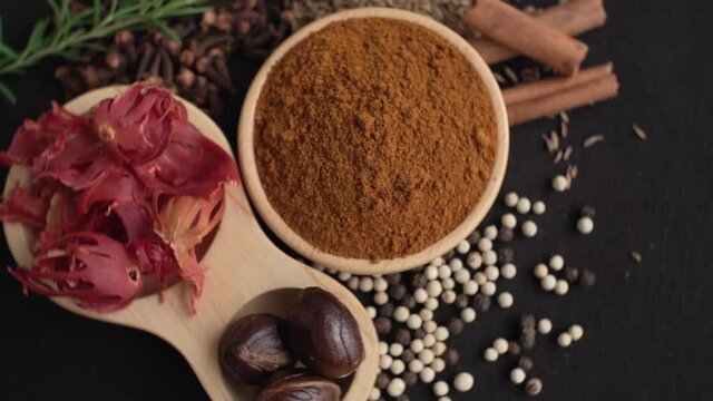 Close up of Curry powder and spices in a wooden cup with black background, industry concept