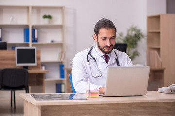 Young male doctor sitting in the office