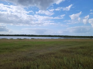 Clouds over a field and a river