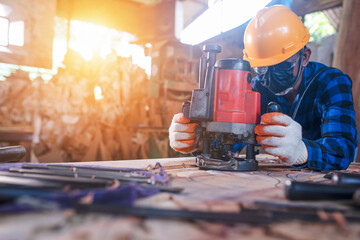 Close-up of an Asian carpenter using a hacksaw in a sawmill.