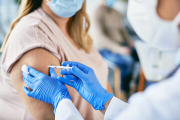 Close-up of female patient getting vaccinated against coronavirus.