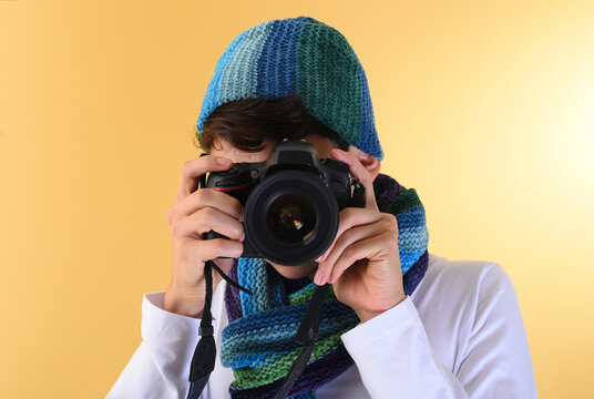 Young photographer practicing studio photography with his reflex camera, concept taking photos.