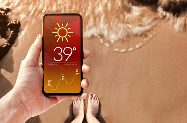 High Temperature Weather Forecast show on Mobile Screen on Hot Summer Sunny Day. Technology for Ecology Concept. Sand Beach with Sunlight as background. Top View