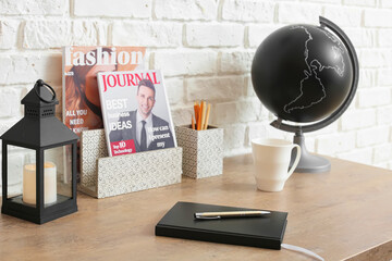 Table with notebook and organizers near brick wall