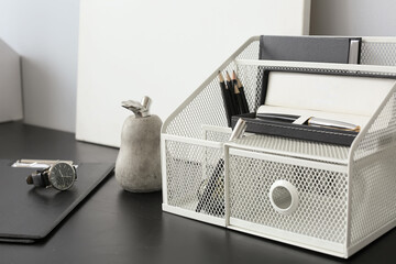 Modern organizer with stationery on table, closeup
