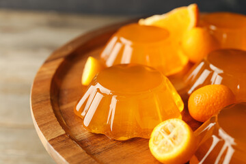 Plate with tasty orange jelly on wooden background, closeup - obrazy, fototapety, plakaty