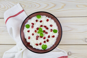 Curd rice in a bowl. A popular dish from South India with rice, yogurt, spices, pomegranate. Top view. Close-up