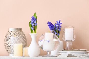 Beautiful composition with hyacinth flowers and burning candles on dining table