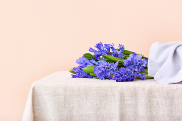 Beautiful hyacinth flowers on table against color background