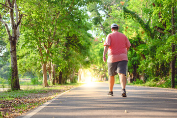 Fat man exercising By walking to burn fat And run slowly to exercise in the park
