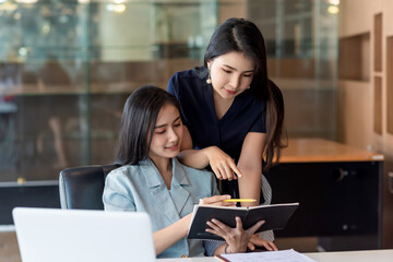 Team of beautiful Asian businesswoman analyzes their work and pointing the documents at the office.