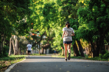 Back view of woman jogging or running exercising outdoors in park, Concept of healthy lifestyle.