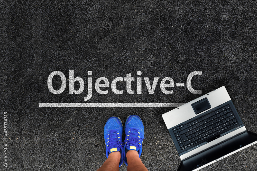 Poster objective-c programming language. legs in sneakers standing next to laptop and word objective-c