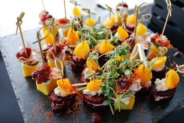 A set of mango, bacon and greens appetizers on a buffet table. 