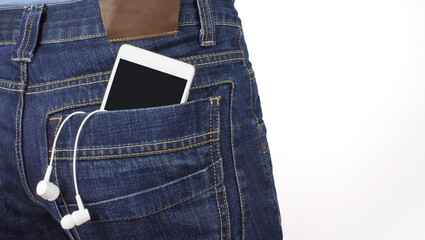 Smartphone with a transparent screen in pocket of jeans near earphones. Music concept.