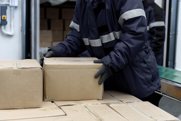 Picking up package boxes in the loading area of cold storage warehouse prepare to transfer storage...