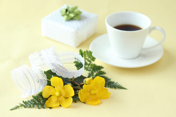 Obraz na płótnie Canvas 黄色の可愛い花　ヒペリカムの花束とプレゼントとコーヒー