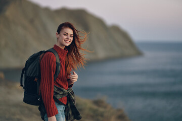 woman with backpack red sweater model and mountains ocean nature