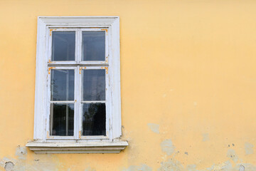 Fototapeta na wymiar Old wooden window and bright yellow wall.