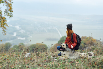 woman outdoors in the mountains next to the dog friendship travel