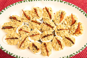stuffed eggs with fried ham on oval plate