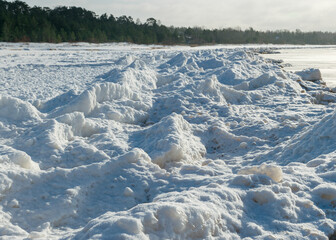 winter landscape by the sea, snowy, interesting ice shapes on the sea shore, dunes covered with a white layer of shining snow