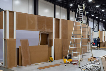 Stepladder and plywood structures in the exhibition hall. Preparation for the exhibition....