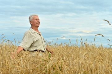 Naklejka na ściany i meble Mature man enjoying fresh air at wheat field