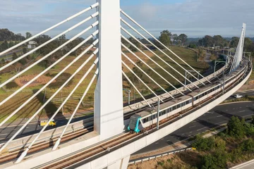 Plexiglas foto achterwand A Sydney metro train crosses a bridge over Windsor Road, Rouse Hill, NSW, Australia © Harley Kingston
