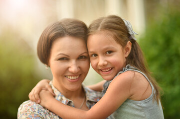 Portrait of happy mother and daughter smiling outdoors