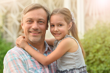 Happy father and daughter hugging outdoors