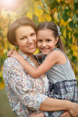 Fototapeta na wymiar Portrait of happy mother and daughter smiling outdoors