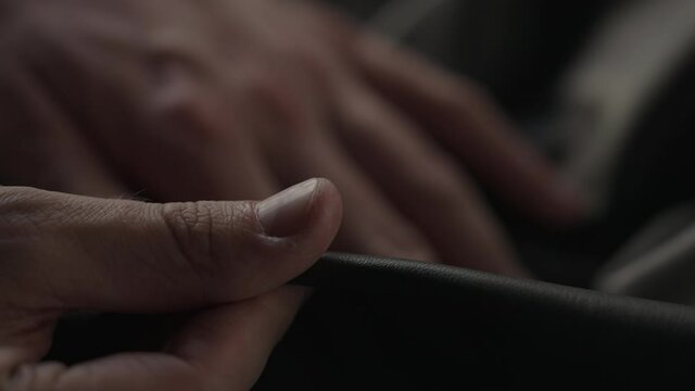 Slow motion man hand touching soft leather with sun shining from a window