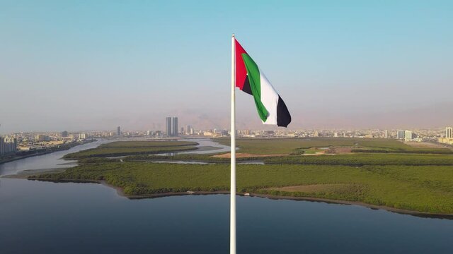 Static slow motion view of UAE flag and Ras al Khaimah emirate in the north United Arab Emirates aerial skyline landmark view