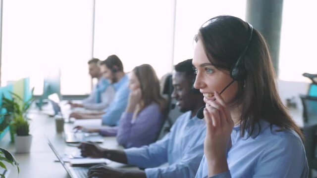 Attractive positive young businesspeople and colleagues in a call center office.