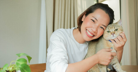 close up beautiful asian woman smile with charming adorable cat in living room for cat lover and...