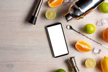 Preparing cocktail at home. Watching recipe of cocktail on smartphone to making at home.