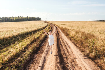 Little girl running on country road. Freedom.