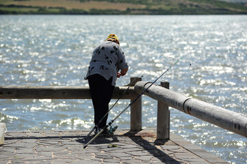 vecchio pescatore a canna dal pontile