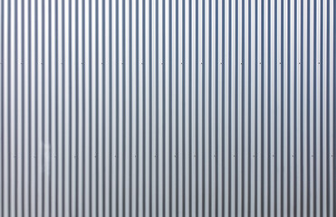 Texture of a wall made of silver corrugated sheet. Exterior wall of a warehouse made of aluminum sheet.