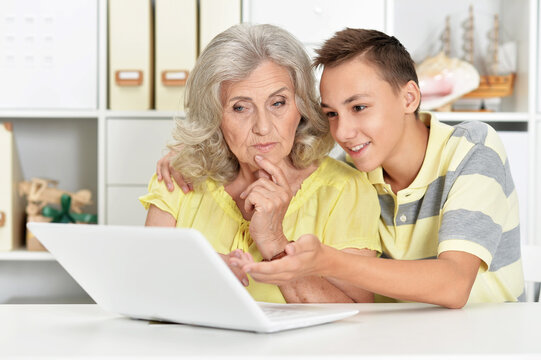 grandmother with her grandson using laptop at home