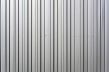 Texture of a wall made of silver corrugated sheet. Exterior wall of a warehouse made of aluminum...