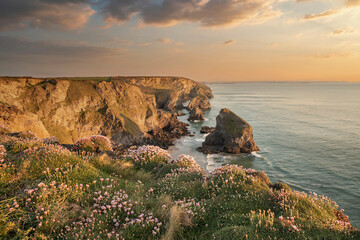 Beautiful landscape image during Spring golden hour on Cornwall coastline at Bedruthan Steps