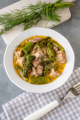 Turkey stew in gravy with asparagus and dill. Meat goulash