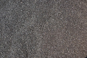Texture of a dark asphalt road surface.Small black stones.