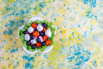Salad with mozarella cheese, olives and cherry tomatoes.