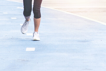 Half body of woman black suit with running shoes  or exercising woman legs on blue running track. fitness, sport, training, people, lifestyle, healthy concept.