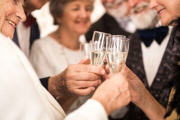 Group of older happy friends toasting with champagne during New Year's Eve